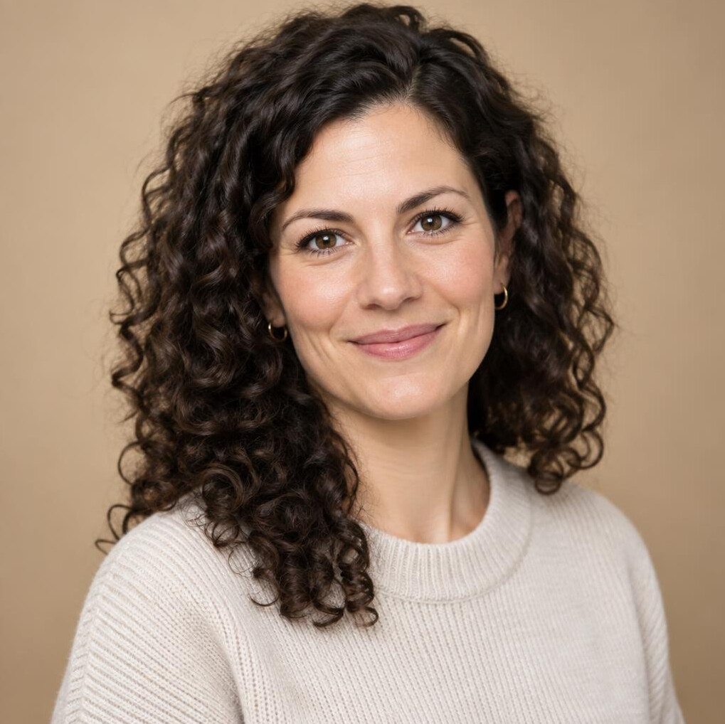 Studio portrait of a German woman in her 30s with dark curly hair